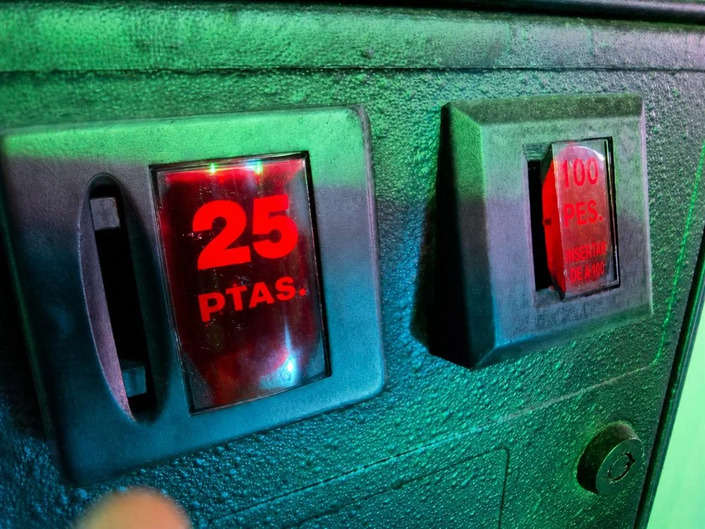 Ranuras de 25 y 100 pesetas de una recreativa, ambas enfocadas